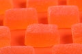 Tasty orange jelly candies on coral background, closeup Royalty Free Stock Photo