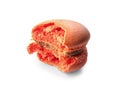 Tasty orange macaron with bite mark on white background