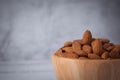 Tasty organic peeled almond snack in wooden bowl on white wooden background with copy space.Close up heap almonds shelled nut .