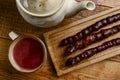 Tasty oriental sweets on wooden tray and glass of tea, on rustic wooden background. Georgian tea concept, tea time