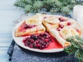 Tasty pancakes with a banana, maple syrup and cranberries