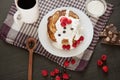 Tasty pancakes with blueberries and raspberries on cotton towel on dark table, cup of tea or coffe, spoon, pieces of chocholate,