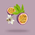 Tasty passion fruit, passiflora leaf and flower falling on pink background