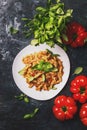 Tasty pasta with minced meat and tomato sauce with green basil on white plate, dark background kitchen table, top view Royalty Free Stock Photo