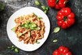 Tasty pasta with minced meat and tomato sauce with green basil on white plate, dark background kitchen table, top view Royalty Free Stock Photo