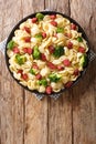 Tasty pasta orecchiette with broccoli and grilled sausages in a creamy sauce close-up in a plate. Vertical top view Royalty Free Stock Photo