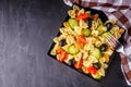 Tasty pasta salad with tomato cucumber and olives on a dark stone background Royalty Free Stock Photo
