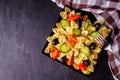 Tasty pasta salad with tomato cucumber and olives on a dark stone background Royalty Free Stock Photo