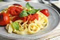 Tasty pasta with tomatoes and basil on wooden table, closeup Royalty Free Stock Photo