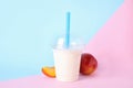 Tasty peach milk shake in plastic cup and fresh fruit Royalty Free Stock Photo