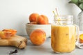 Tasty peach smoothie in mason jar and fresh frui