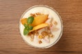 Tasty peach yogurt with granola, mint and pieces of fruit in dessert bowl on wooden table, top view Royalty Free Stock Photo