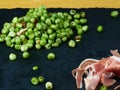 Tasty Peas with ham and sliced ham on a black slate board. Close up view