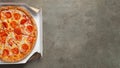 Tasty pepperoni pizza in a box on brown concrete background. Top view of hot pepperoni pizza. With copy space for text. Flat lay Royalty Free Stock Photo