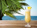 Tasty pineapple cocktail in glass on wooden table at beach, space for text Royalty Free Stock Photo