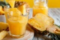 Tasty pineapple juice in glass with pineapple fruit slices. Fresh natural pineapple cocktail and juice in glass on white wooden Royalty Free Stock Photo