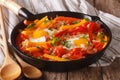 Tasty Piperade: fried eggs with peppers and tomatoes close up in Royalty Free Stock Photo