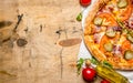 Tasty pizza with bacon and tomatoes. On wooden table. Royalty Free Stock Photo