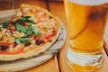 Tasty pizza and glass of beer are on wooden table Royalty Free Stock Photo