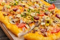 Tasty pizza with mushrooms, chicken, pepperoni, olives, corn cut into pieces. Royalty Free Stock Photo