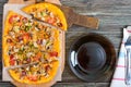 Tasty pizza with mushrooms, chicken, pepperoni, olives, corn cut into pieces on a wooden tray. Royalty Free Stock Photo