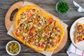 Tasty pizza with mushrooms, chicken, pepperoni, olives, corn cut into pieces on a wooden tray. Royalty Free Stock Photo