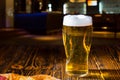 Tasty pizza table near a glass of beer, restaurant in the background Royalty Free Stock Photo