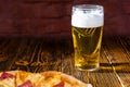 Tasty pizza on wooden table near a glass of beer Royalty Free Stock Photo