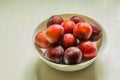 Tasty plums in a bowl on the counter