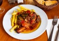 Tasty pork knuckle with potatoes and stewed peppers served Royalty Free Stock Photo