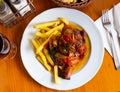 Tasty pork knuckle with potatoes and stewed peppers served Royalty Free Stock Photo