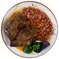 Tasty pork meat with side dish of stewed white beans. Traditional Spanish cuisine
