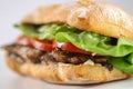 Tasty pork steak sandwich in a ciabatta with tomatos, lettuce