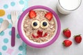 Tasty porridge served with berries, jam and milk on table, flat lay. Creative idea for kids breakfast