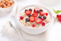 Tasty porridge with strawberry slices, black and red currants