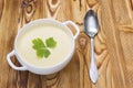Tasty potato soup with a leaf of parsley, rustic wooden table. Potato and onion vegan, vegetarian healthy cream soup in white cera Royalty Free Stock Photo