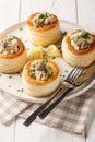 Tasty puff pastry vol-au-vent stuffed with chicken, mushrooms and cream closeup on the plate. Vertical