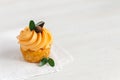 Tasty pumpkin cupcake with orange cream and decoration on white wooden table Royalty Free Stock Photo