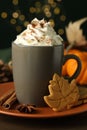 Tasty pumpkin spice latte with whipped cream in cup and cookies on table, closeup Royalty Free Stock Photo