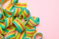 Tasty rainbow sour belts on pink background, top view. Space for text Royalty Free Stock Photo