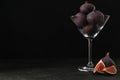Tasty raw figs in martini glass on black table. Space for text Royalty Free Stock Photo
