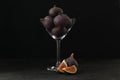 Tasty raw figs in martini glass on black table Royalty Free Stock Photo