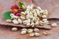 Tasty Raw pistachio nuts with leaves on brown tree rind background Royalty Free Stock Photo