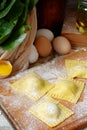 Tasty raw ravioli with ricotta and spinach, with flour and eggs on wooden background. Process of making italian ravioli. Royalty Free Stock Photo