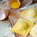 Tasty raw ravioli with ricotta and spinach, with flour and eggs on wooden background. Process of making italian ravioli. Royalty Free Stock Photo