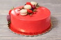 Tasty red homemade cake decorated by red candies and macarons