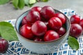 Tasty ripe plums in bowl on grey table, closeup Royalty Free Stock Photo