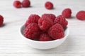 Tasty ripe raspberries in bowl on white wooden table, closeup Royalty Free Stock Photo