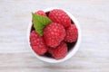 Tasty ripe raspberries and green leaf on white wooden table, top view Royalty Free Stock Photo