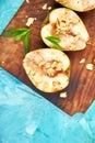 Tasty roast pears with honey and walnuts on wooden board on blue background table. Royalty Free Stock Photo